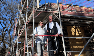 Bürgermeisterin steht neben Zimmermann auf dem Baugerüst.